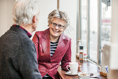 年长夫妇在咖啡馆窗口座位上聊天图片