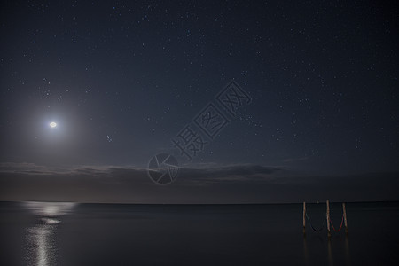 星空和满月照亮水域上的标志吊床墨西哥图片