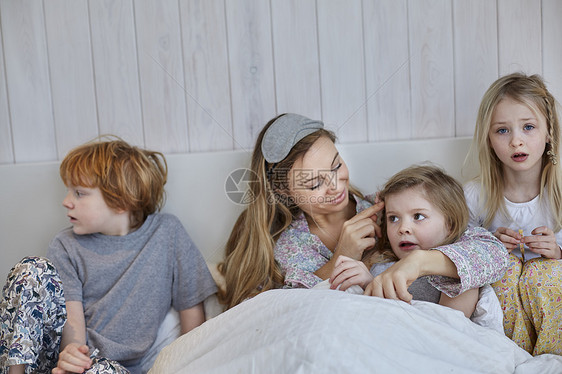 母亲和孩子们一起躺在床上玩图片