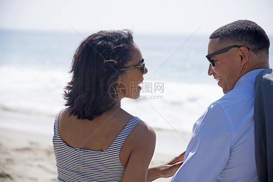 在海滩上聊天的情侣图片