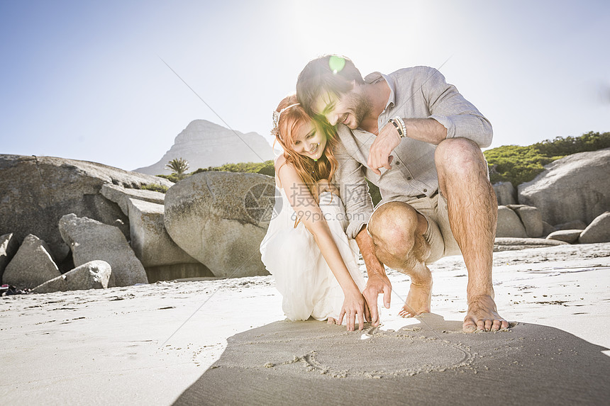 夫妻在沙滩上画爱心图片