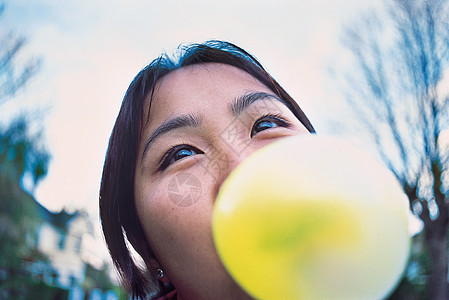 年轻女子吹泡泡糖的肖像特写图片