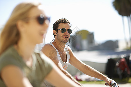 美国加利福尼亚州洛杉矶威斯海滩骑自行车的年轻情侣图片