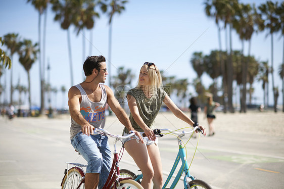 威斯海滩骑行的情侣图片
