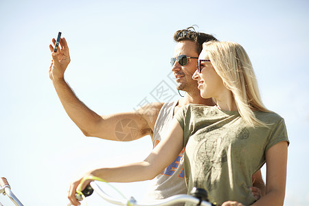 一对夫妇使用智能手机自拍图片