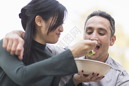 妇女喂食男子吃沙拉图片