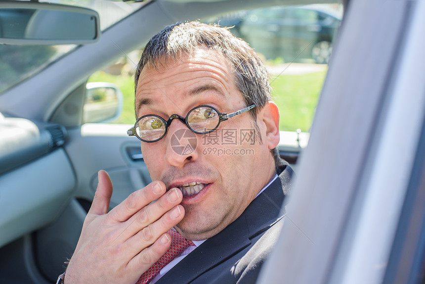 坐在车里的人戴眼睛镜嘴对看着镜头图片