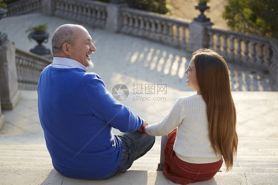 看着祖父和孙女坐在台阶上面对微笑图片