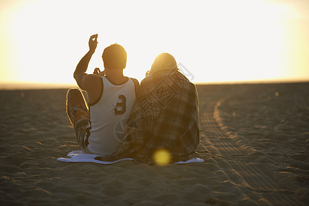 日落时在海滩上的情侣图片