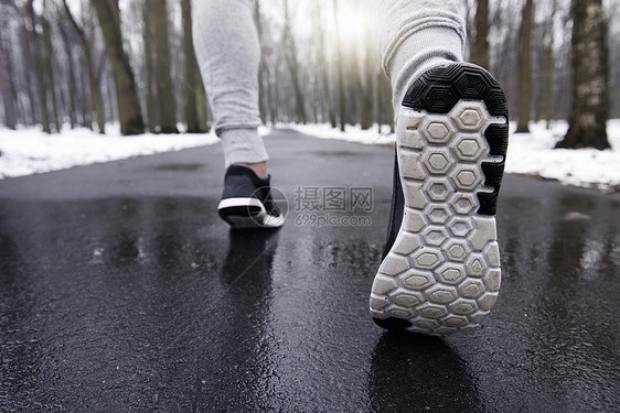 年轻男子在雪林中慢跑特写图片