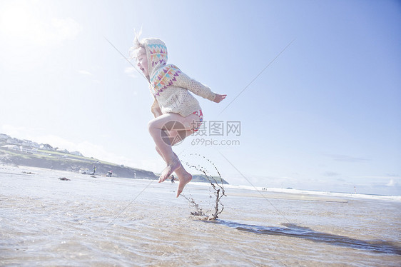 女孩在海滩上跳跃图片
