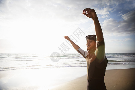 男人在沙滩上高举双臂图片
