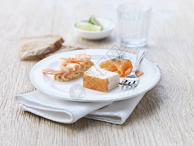 白色盘子上的生鱼片和虾肉图片