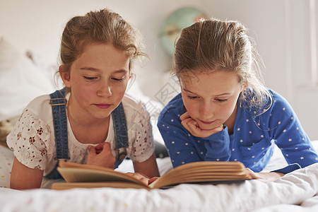 两姐妹躺在床上看书图片