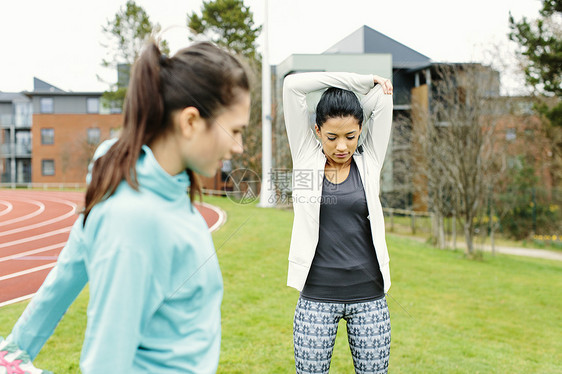 两名女青年在户外做运动伸展图片