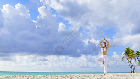 身着比基尼的女青年在多米尼加勒比海滩上做瑜伽图片