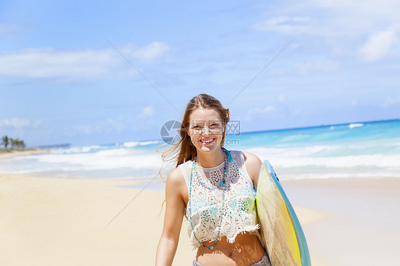 多米尼加勒比海滩上携带冲浪板的年轻妇女肖像图片