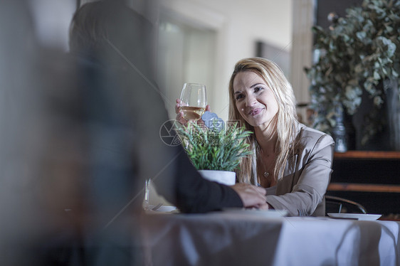 在餐馆与朋友一起吃饭聊天的成熟女性图片