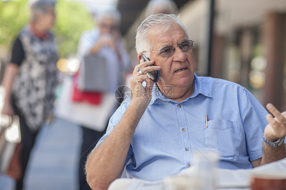 男子在咖啡馆外使用移动电话图片
