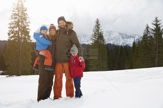 在雪地中父母和儿子在微笑图片