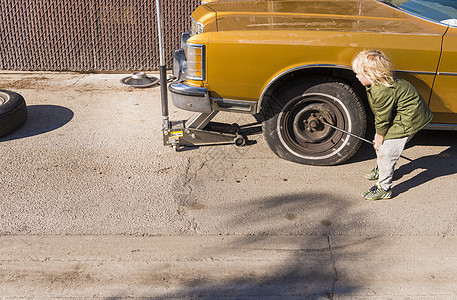 男孩从扁轮胎上取出式坚果图片