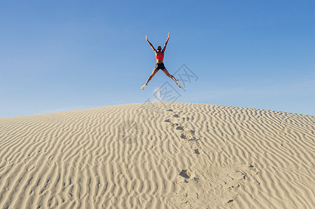 美国加利福尼亚州死地亡谷沙漠赛马手和腿跳起来图片