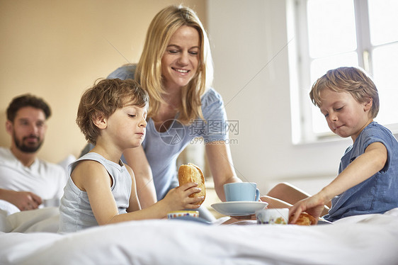 男孩在父母床上吃早餐图片