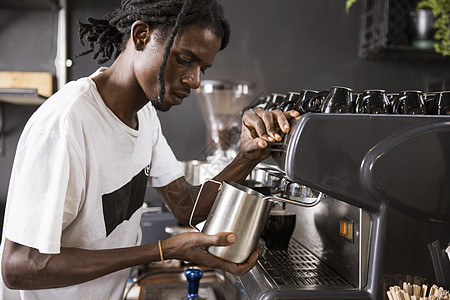 咖啡师用咖啡机使牛奶起泡图片