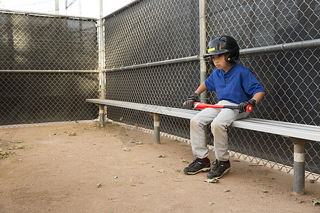 棒球男孩坐在练习的板凳上图片