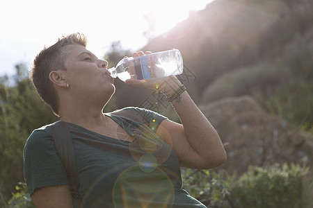 来自塑料瓶子的妇女饮用水图片