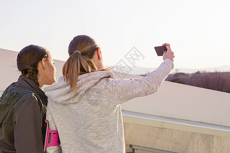 两个女朋友在户外用手机拍照图片