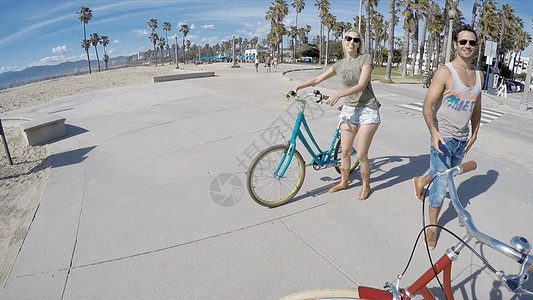 海滩边骑车的青年情侣图片