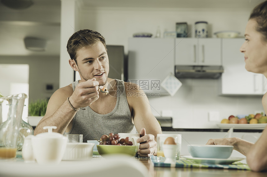 在厨房吃早餐的年轻夫妇图片