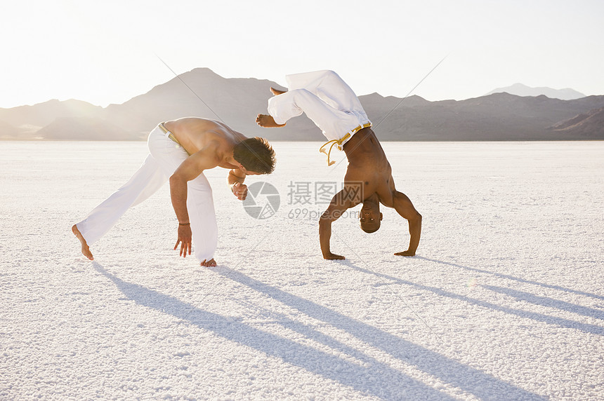 美国犹他州博纳维尔盐滩上两名男子表演杂技图片
