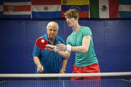 男教练教男子打乒乓球图片