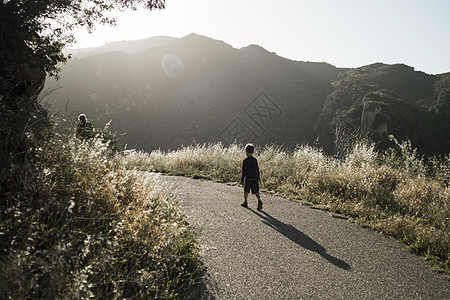 沿农村公路行走的男孩图片