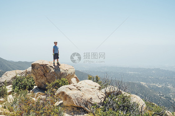 站在巨石上的男孩图片