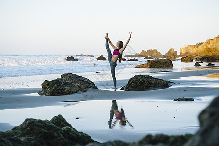 年轻女性在美国加利福尼亚州洛杉矶海滩上拉伸图片