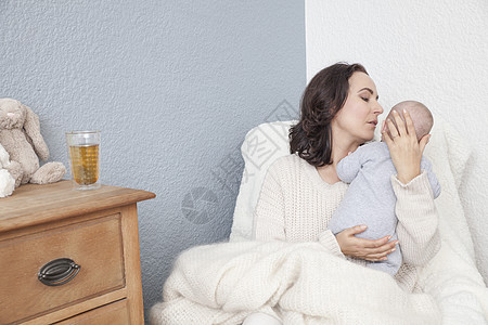 母亲坐在椅子上安慰宝宝图片素材