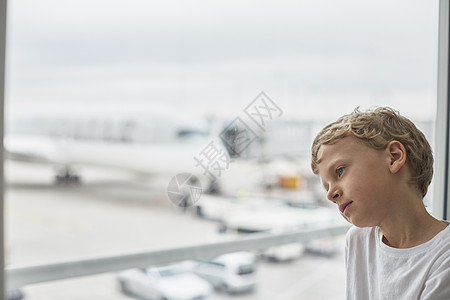 男孩望向机场窗外图片