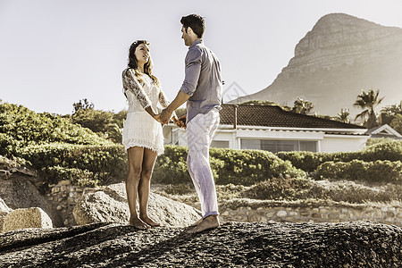 在南非开普敦海滩上手牵手站在一起的情侣图片