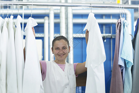 正在挂衣服的洗衣店工人图片