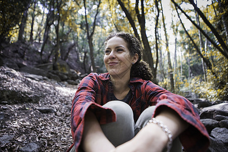 美国加利福尼亚州森林中的年轻女远足者笑着看外面图片