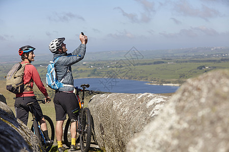 带自行车骑在岩石边缘拍照图片
