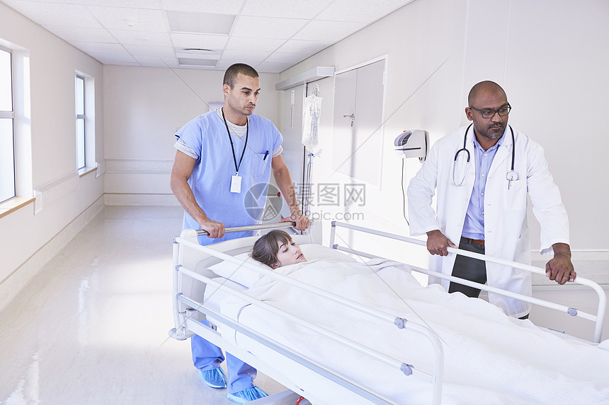 医生在走廊里推躺着病人的病床图片