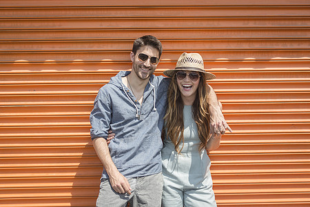 美国纽约布鲁克林科尼岛内一对夫妇靠在橙色车库前看摄像机图片
