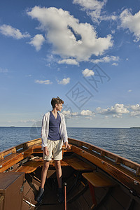 少年男孩站在船上向外看图片