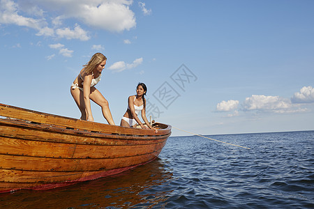 在海中船上穿着泳衣的妇女两图片