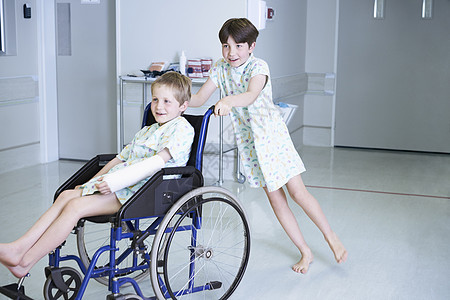 在医院儿童病房轮椅上推朋友的男孩病人图片