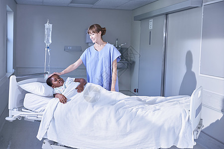 在医院儿童病房床上照顾孩子的护士图片